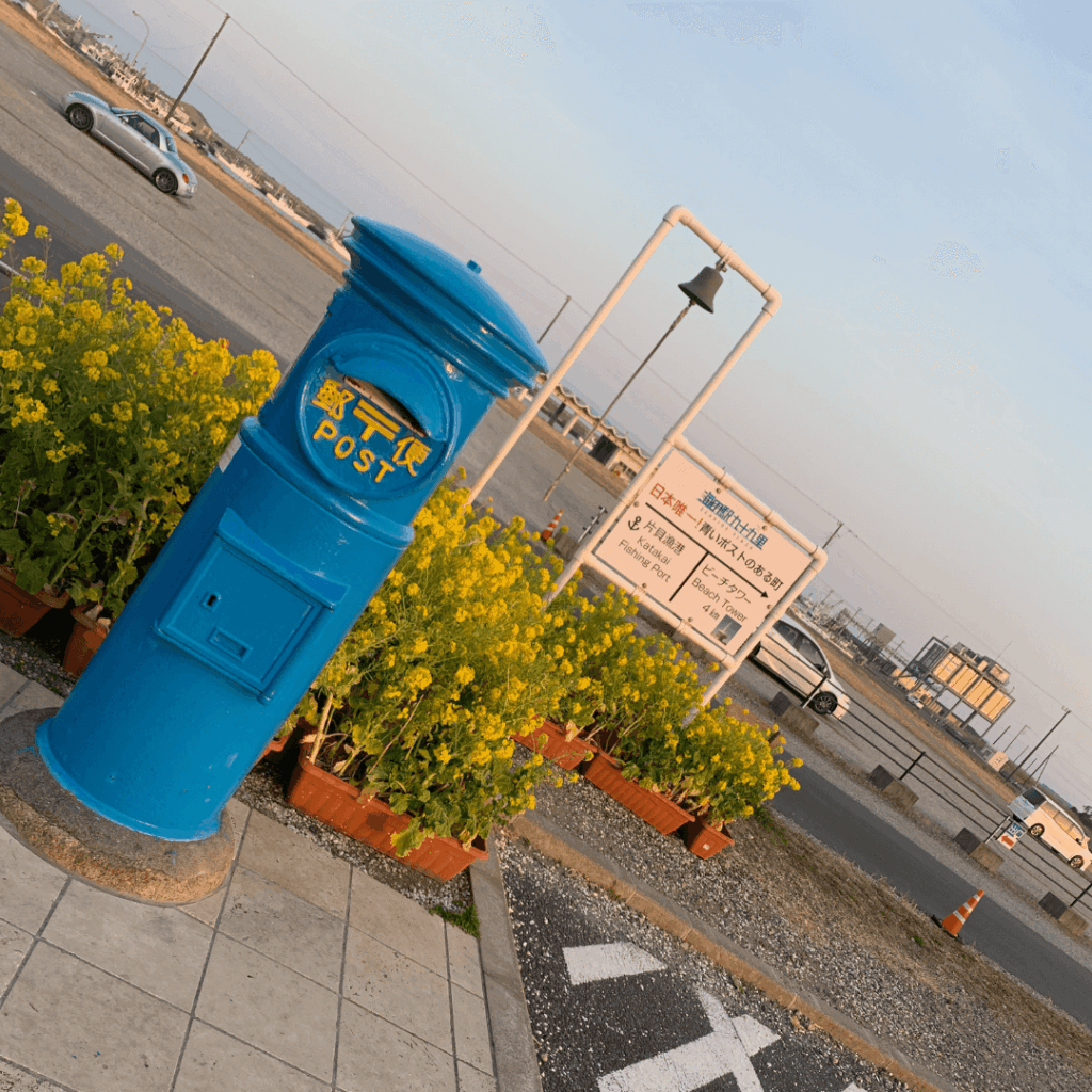 青いポストと菜の花の黄色